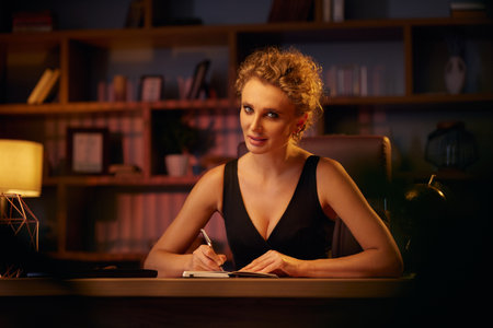 Purposeful young business woman, professional entrepreneur, reads a book. Business woman in a beautiful office in cinematic light. A beautiful portrait.の写真素材