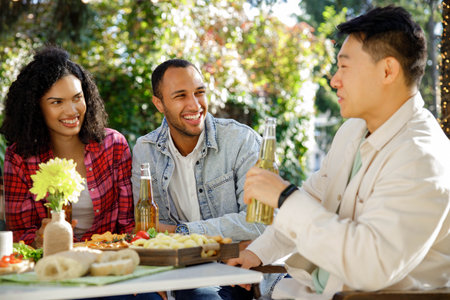 A group of friends are relaxing in nature. Boys and girls of different nationalities and races have fun talking, telling stories, and having fun outside the city.の写真素材