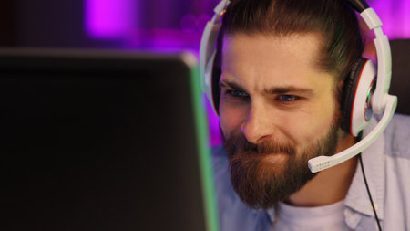 Close-up portrait of an esportsman. A professional gamer plays a computer video game, communicates in a headset with a team at the E-Sport championship. cyber gaming arena.の写真素材