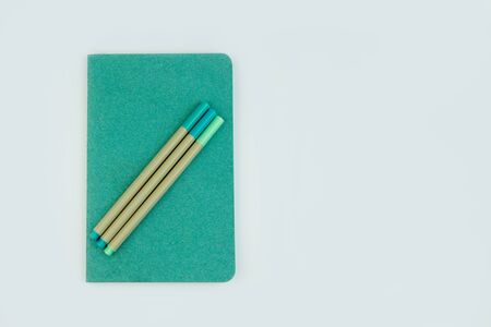 Green notebook on white surface. Close Up, copy space, top view. Minimalist concept. Colors of Year.の写真素材