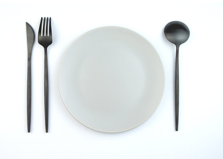 Empty plate and modern cutlery isolated on white background. Stylish setting.の写真素材