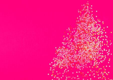 Golden star sprinkles on bright pink. Festive holiday background. Celebration concept. Top view, flat lay.の写真素材