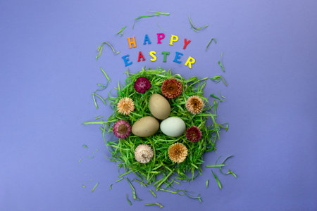 Easter composition with nest, eggs and colorful letters on violet background. Text Happy Easter....