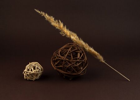 Geometric composition of decorative orbs weaved from willow on a brown background. Natural eco material.の写真素材
