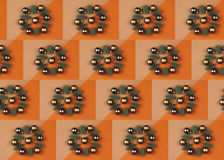 Pattern made of Christmas balls and spruce branches on beige and orange background. Creative New...