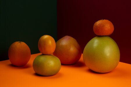 Multicolored geometric composition with various citrus fruits on a triangular background. Front view.の写真素材