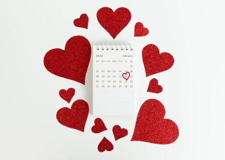 February calendar. Date February 14 is circled by a heart. Surrounded by a glitter red hearts. Valentines day.の写真素材