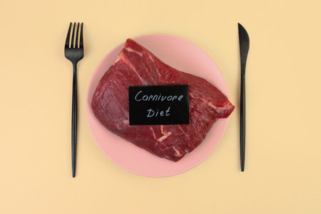 A piece of raw meat lies on a plate. Veal tenderloin. Predatory diet label. Zero carbohydrate diet...