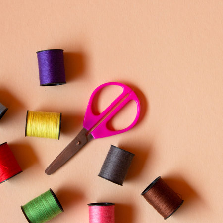 Creative composition with spools of colored threads and scissors. Sewing accessories, tailoring set....