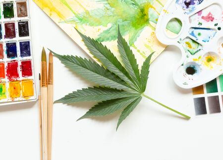 Set of watercolor paints, art brushes, palette and blank album. Marijuana leaf. Cannabis reveals creativity. The concept of art.の写真素材