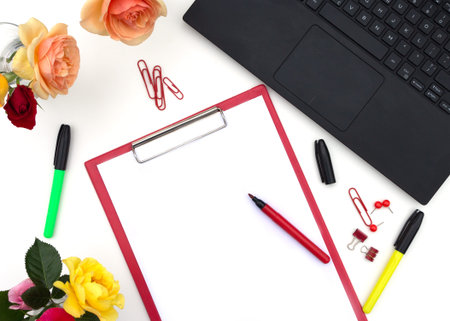 Workplace in office or home with computer, notebook, supplies, cup of tee and roses flowers. Space...