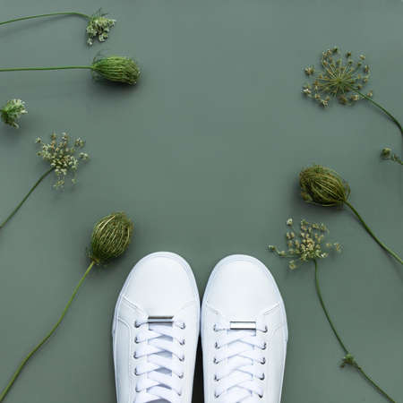 Pair of White sneakers on green background. Concept of healthy lifestyle and food, everyday training and force of will.の写真素材