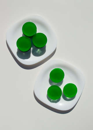 Two-layer jelly made from pandanus leaves and coconut milk. Traditional Thai street food. Lao Wun. Modern minimalist still life. Natural green dye.の写真素材