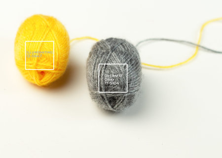 Yellow and gray ball of woolen thread on a white background. Illuminating and Ultimate Gray. Color...