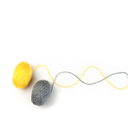 Threads for knitting fashionable sweaters.Yellow and gray ball of woolen thread on a white background. Illuminating and Ultimate Gray. Color of the year 2021.の写真素材