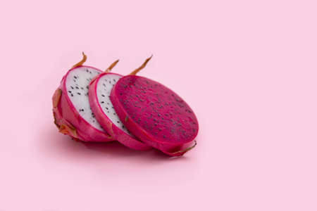 Red and pink dragon fruit slice with red and white flesh. The pitahaya fruit is low in calories, rich in essential vitamins and minerals, and contains dietary fiber.の写真素材