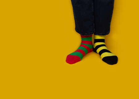 Legs with multicolored different stripes socks on background with copy space. World Down syndrome day background. Down syndrome awareness concept.の写真素材