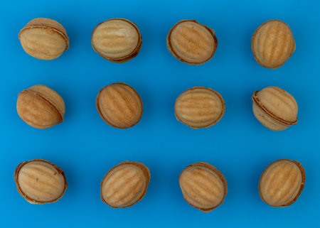 A group of nut-shaped cookies stuffed with boiled condensed milk on a blue background.の写真素材