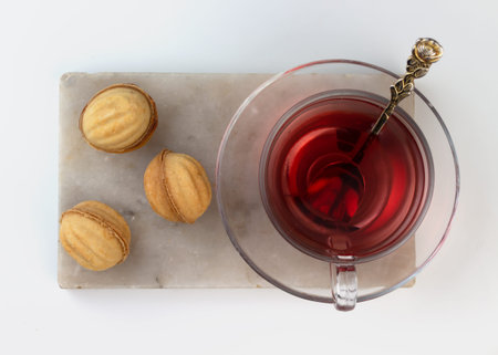 Homemade nut-shaped cookies stuffed with condensed milk in a glass vase on a marble cutting board....