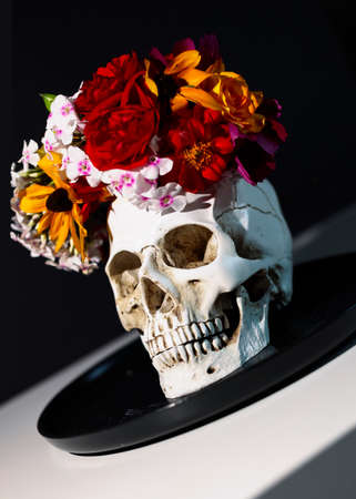 Skull with flowers wreath. Concept of Day of the dead, Dia De Los Muertos. Halloween Celebration Decor. Creative still life.の写真素材