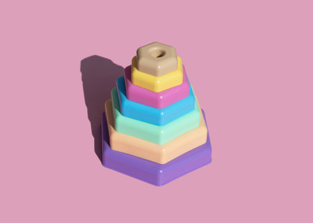 Children's toy constructor pyramid herringbone in pastel colors on a pink background. Minimalism, shadowの写真素材