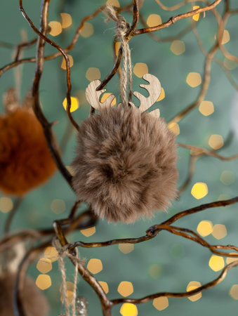 Alternative twig tree is decorated with fluffy faux fur balls in neutral brown tones.の写真素材
