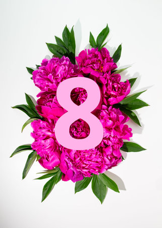 Number eight cut out of paper. Pink peonies flowers below 8 shape. Womens day card.