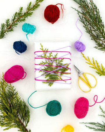 Original gift wrapping idea for Christmas. Recycled paper, colored wool threads and juniper twigs....
