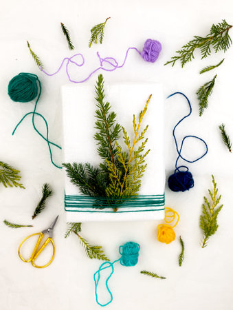 Original gift wrapping idea for Christmas. Recycled paper, colored wool threads and juniper twigs....