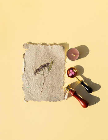 Wax printing with fire paint on homemade kraft paper with pressed dried flowers. Sealing wax seal kit.の写真素材