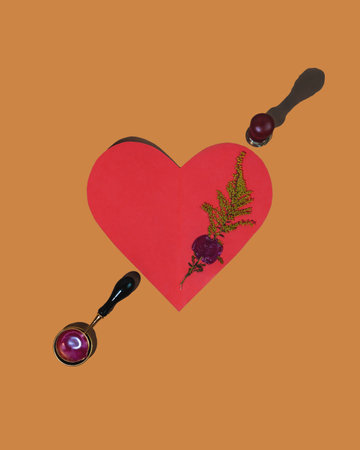 Homemade card for valentine's day in the shape of a red heart. Decorated with a pressed dry branch of goldenrod, which is sealed with sealing wax. Environment friendly decoration.の写真素材