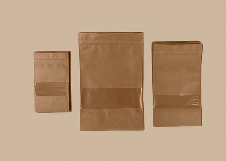 Brown kraft paper doypack bags with groceries front view on a yellow background. Packaging for foods...