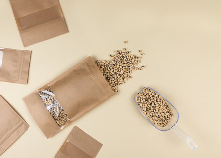 Brown kraft paper doypack bags with black-eyed peas on a yellow background. Packaging for foods and goods template mock-up. Packs with windows for weight products.Top viewの写真素材