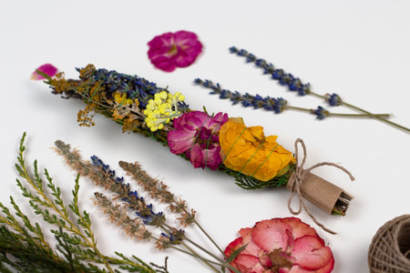 DIY smudge stick to banish bad energy. Dried herbs and flowers are tied into a bundle with a thread. Homemade incense stick for the mental practice of mindfulness meditation. copy spaceの写真素材