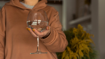 Woman holds a glass of clean water. The concept of dry January and sober October. Avoiding alcohol throughout the month. healthy lifestyle.の写真素材