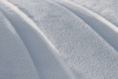 Traces from the car on a snowy road in the field.の写真素材