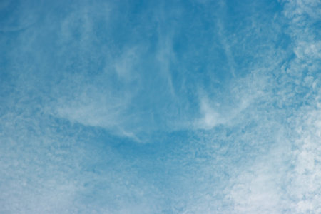 Partly cloudy in the blue summer sky during the day.