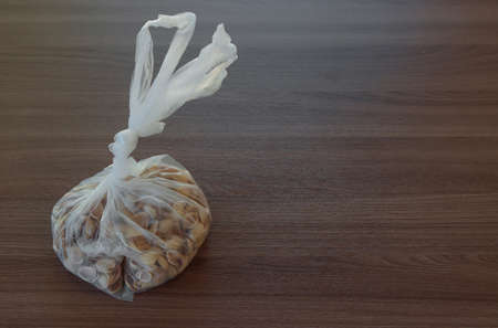 Background with empty pistachio nuts without kernel in a transparent cellophane bagの写真素材