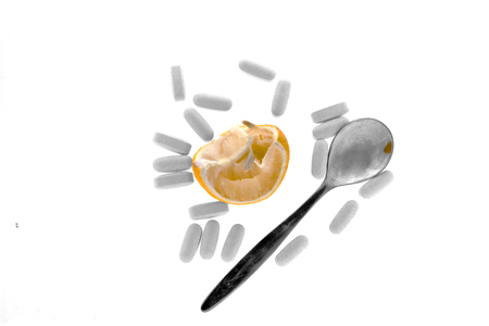 The composition on the theme of drugs - pills, squeezed lemon and a teaspoonの写真素材