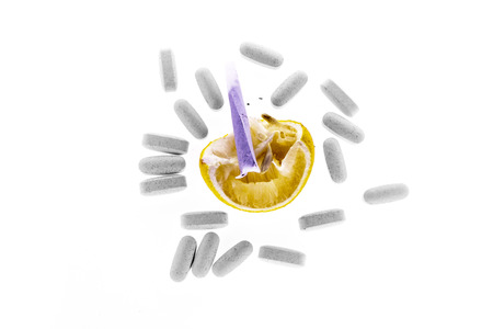 The composition on the theme of drugs - pills, squeezed lemon and a teaspoonの写真素材