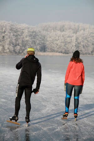 Boy using his mobile phone while skating together with his girlfriendの写真素材