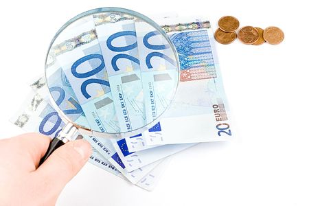 Isolated euro money under the reading glass kept in handの写真素材