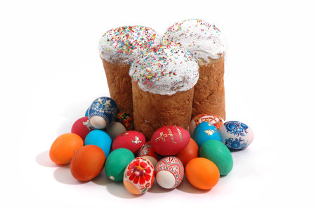 Kulich and colored eggs on a white background
