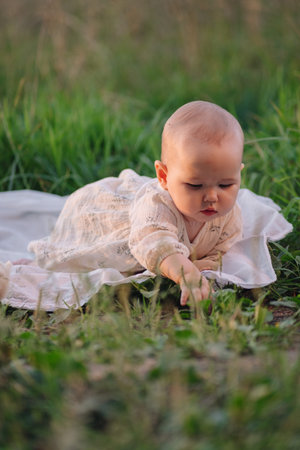 a one-year-old child in a clearing crawls towards the viewer