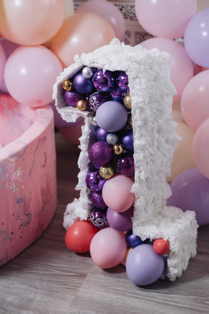 birthday cake with purple and pink balloons and ribbons on wooden backgroundの写真素材