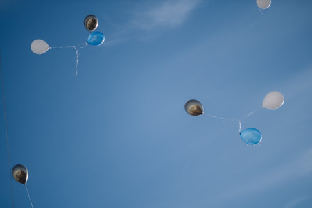 A bunch of multicolored balloons with helium on a blue sky backgroundの写真素材