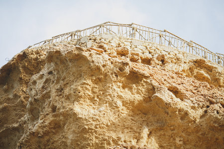 Close up view of a rock with a metal fence on it.