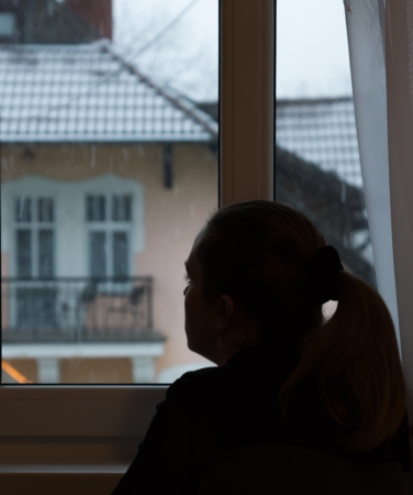The silhouette of the girl who sits before a window and looks afar の写真素材