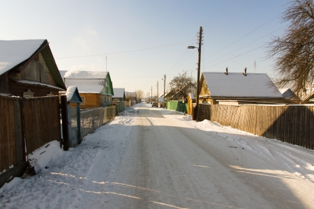 strewn road passes through the frozen snow villageの写真素材