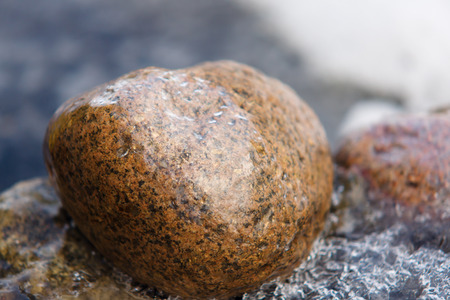 the big stone in an ice cover expects springの写真素材